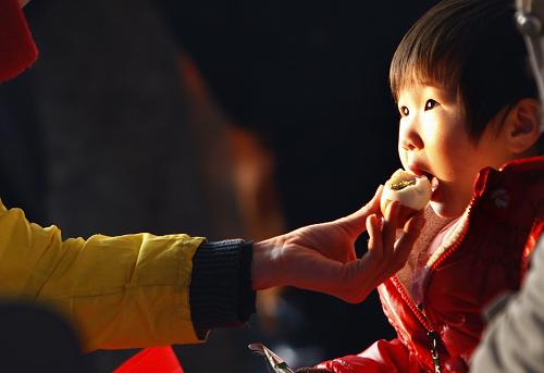 1月8日,在北京站的候車室里,孩子正在吃母親剝好的雞蛋。 當(dāng)日,中國的交通運(yùn)輸開始進(jìn)入春運(yùn)時(shí)段,很多孩子也在這一時(shí)間里踏上旅途,在茫茫人海中經(jīng)歷自己的春運(yùn)生活。 新華社發(fā)(萬象攝)