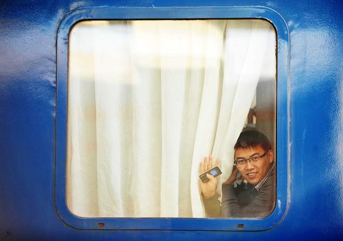 1月8日,在哈爾濱火車站,一位旅客從車窗向外揮手。當(dāng)日,2012年全國(guó)春運(yùn)正式啟動(dòng)。旅客啟程前的喜怒哀樂透過一扇扇車窗紛紛展露。新華社記者 王建威 攝