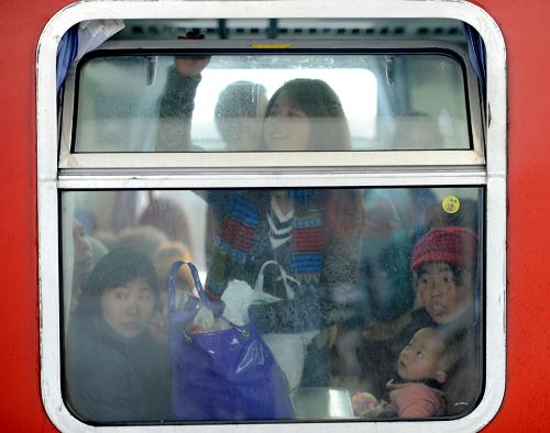 1月8日,杭州開往烏魯木齊的列車上,旅客在火車開動(dòng)前向車窗外張望。新華社記者 韓傳號(hào) 攝