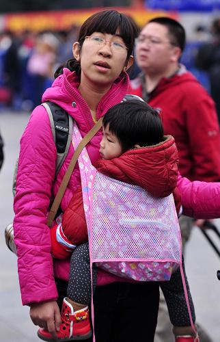 1月20日,一名帶著孩子的旅客在廣州火車站廣場準備進站。新華社記者 陳曄華 攝