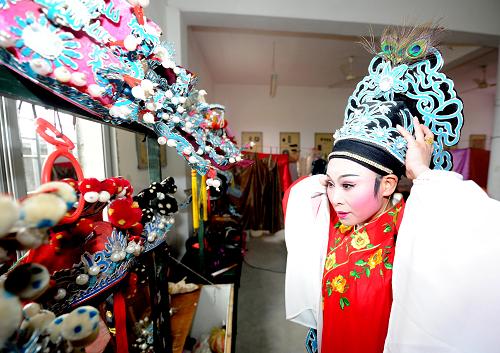 2月2日,紹興百花劇團(tuán)的越劇演員正在佩戴頭飾,準(zhǔn)備上臺演出。新華社記者 徐昱 攝