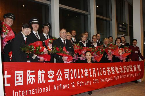 2月12日清晨,在北京首都國際機(jī)場,執(zhí)行瑞士航空蘇黎世至北京直飛航班首航的機(jī)組人員與北京地面工作人員合影留念。新華社發(fā)(付琪 攝)