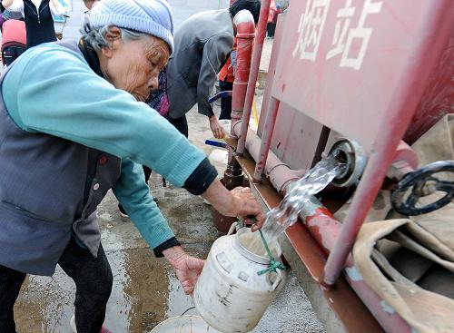 2月15日,云南曲靖市羅平縣維則村一名老人在接水。新華社記者 楊宗友 攝