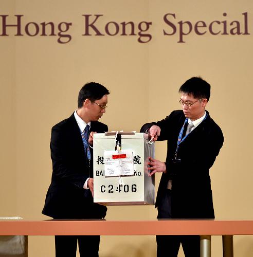 3月25日,兩名工作人員將票箱搬入中央點票區(qū)。新華社記者 陳曉偉 攝