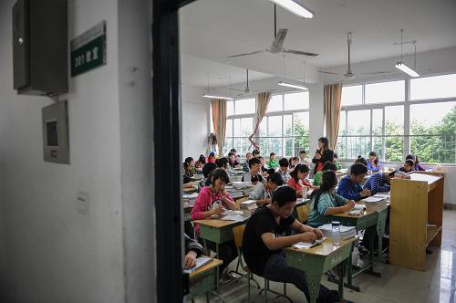 5月21日,學(xué)生在位于靈創(chuàng)科技園的臨時教室里上課。5月19日至22日,“四川災(zāi)區(qū)重建中學(xué)被拆建豪宅”的消息引爆網(wǎng)絡(luò)輿論,各大門戶網(wǎng)站、論壇和微博大量轉(zhuǎn)發(fā),一所使用僅2年的重建學(xué)校為何突然被拆除?目前學(xué)生上課的情況怎樣?災(zāi)后重建中善款使用到底面臨怎樣的問題?記者趕赴綿陽市進(jìn)行了深入采訪。新華社記者 李橋橋 攝