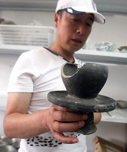 工作人員展示從上海廣富林遺址考古發(fā)掘區(qū)出土的器物(6月6日攝)。 上海市文物局和上海博物館考古部日前公布了對于形成于4000余年前的廣富林遺址的最新考古發(fā)現(xiàn)。正在進行考古發(fā)掘的1.5萬平方米廣富林遺址也首度向公眾開放展示。 廣富林遺址位于上海松江佘山附近,1959年被發(fā)現(xiàn)。此前的考古發(fā)現(xiàn)已經(jīng)證實,廣富林遺址中的廣富林遺存來自于黃河流域。黃河流域文明和長江流域文明在此發(fā)生融合。 據(jù)介紹,通過廣富林遺址的最新發(fā)掘,已發(fā)現(xiàn)新石器時代、周代、漢代、宋元、明清等時期的大量遺跡,發(fā)現(xiàn)和出土了一批重要文物,包括一處面積約為150平方米的新石器時期倒塌房屋遺址、良渚文化的玉器、廣富林文化的生產(chǎn)工具石斧、石鑿和石錛、周代青銅尊等。 新華社發(fā)(賈東流 攝)