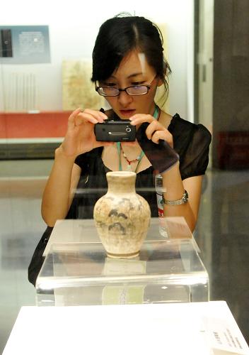 6月9日,一位市民在“河南文物珍寶展”上拍照。當日是中國第七個文化遺產(chǎn)日,河南省文物局主辦的“華夏文明之源——河南文物珍寶展”在河南博物院舉行,本次展覽匯集了河南省18家文物單位收藏的出土文物精品160余件。新華社記者 李博 攝