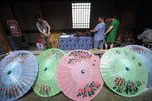6月9日,手工藝人房金泉(左)在現(xiàn)場制作紙傘。當日是我國第七個“文化遺產(chǎn)日”,來自杭州市余杭區(qū)各鄉(xiāng)鎮(zhèn)、街道的80多位手工藝人在西溪濕地開展了一場別開生面的“民間手工藝達人會”,這些“手工藝達人”在活動現(xiàn)場演示風箏編織、紙傘制作、米塑、木雕、繪染等40多項工藝項目,感興趣的參觀者還可以親自動手參與制作,由這些“手工藝達人”現(xiàn)場授課,用互動的方式讓參觀者更直觀感受到傳統(tǒng)手工技藝的魅力。新華社記者 鞠煥宗 攝