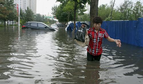 6月17日,行人在積水嚴(yán)重的哈爾濱市紅旗大街上行走。當(dāng)日下午,哈爾濱市出現(xiàn)了短時(shí)強(qiáng)降雨天氣,導(dǎo)致市區(qū)部分路段積水嚴(yán)重。新華社發(fā)(肖勁彪 攝)