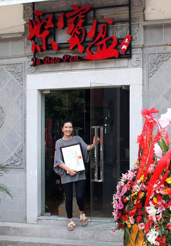 6月21日,店主陳金卿站在她新開張的店鋪門前。新華社發(fā)(丁煥新 攝)