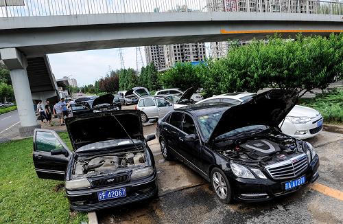 7月22日,安立路立水橋路段,積水清除后,被困車輛因無法自行離開而在等待救援。新華社記者 張宇 攝