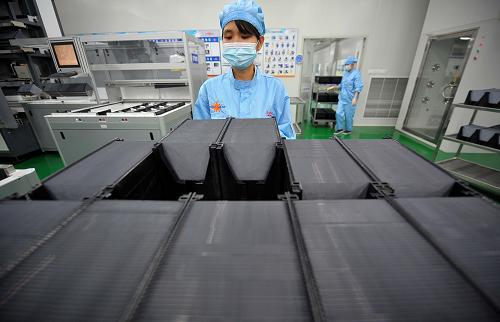 海南英利集團的工作人員在處理硅片(8月22日攝)。新華社記者 郭程 攝