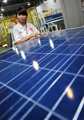 海南英利集團的工作人員在檢查太陽能電池板(8月22日攝)。新華社記者 郭程 攝