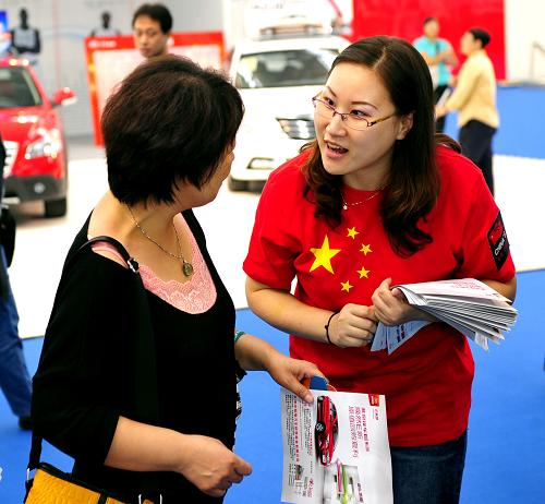 10月3日,在2012天津國際車展上,銷售人員在發(fā)放宣傳資料。 新華社發(fā)(史嵩 攝)
