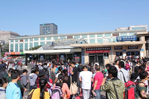 10月5日,抵達(dá)北京火車(chē)站的旅客進(jìn)入地鐵站。新華社發(fā)(王全超 攝)