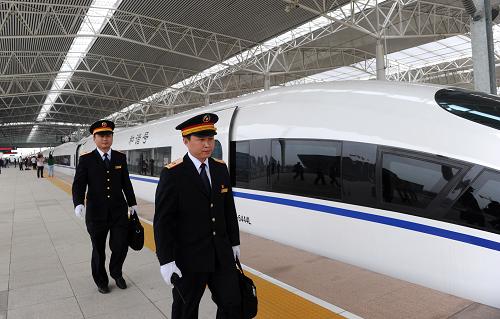 10月13日,在安徽蚌埠南站,兩名工作人員從一列合蚌高鐵列車旁走過。新華社記者 劉軍喜 攝