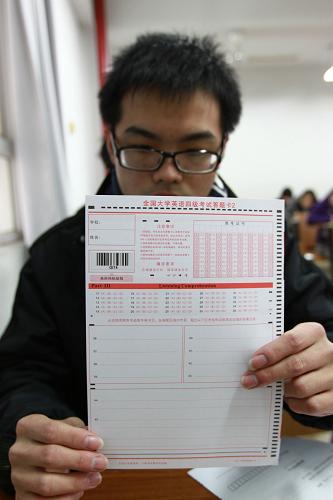 12月22日,在全國(guó)大學(xué)英語(yǔ)四級(jí)考試江蘇大學(xué)考點(diǎn),一名考生展示貼有“多題多卷”條形碼的答題卡。新華社發(fā)(楊雨 攝)