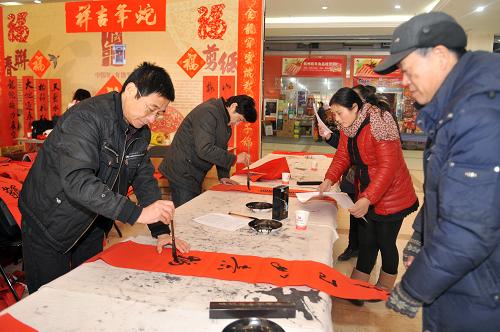 1月18日,書法愛好者在浙江食品市場(chǎng)大廳免費(fèi)為市民寫春聯(lián)福字。 新華社記者 黃宗治 攝