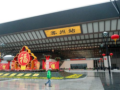 2月5日,人們從蘇州火車站南廣場(chǎng)經(jīng)過(guò)。新華社發(fā)(王建康 攝)