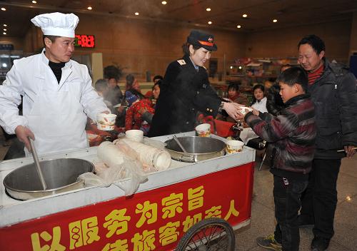 2月9日,鐵路安徽阜陽站工作人員為旅客送上熱氣騰騰的餃子。新華社發(fā)(盧啟建 攝)