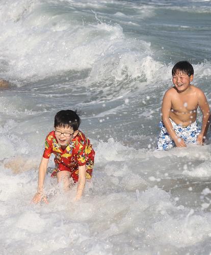 2月11日,小朋友在海南省三亞市海邊游玩,歡度“旅游年”。新華社發(fā)(陳文武 攝)