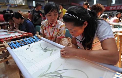 蘆山地震災區(qū)婦女居家靈活就業(yè)培訓啟動 5月20日,在啟動儀式上,一名蘆山地震災區(qū)婦女(右一)學習蜀繡技藝。 當日,“4·20”蘆山地震災區(qū)婦女居家靈活就業(yè)培訓啟動儀式在四川省蘆山縣舉行。據悉,婦女居家靈活就業(yè)是“5·12”汶川特大地震發(fā)生后,四川省婦聯根據住在板房、帳篷里的災區(qū)婦女既要照顧家人、重建家園,又要恢復生產、增加收入的特殊情況探索出的一項幫助婦女就近就便創(chuàng)業(yè)就業(yè)的新模式。 新華社記者劉瀟攝