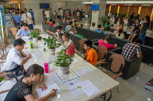7月13日,不少市民在重慶市公安局出入境管理局辦證大廳填表辦證。新華社記者 陳誠(chéng) 攝