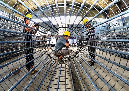 8月3日,在三淅高速公路建設工地的一處工棚內(nèi),幾名工人在捆扎橋梁墩柱的鋼筋籠。新華社記者 王頌 攝