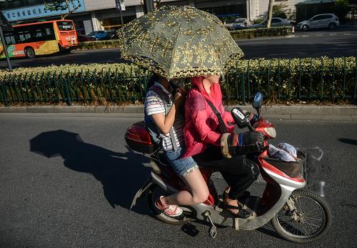8月12日,杭州市民打著遮陽傘騎行在市區(qū)一條道路上。 當日,杭州城區(qū)最高氣溫達到40℃以上,自8月5日起杭州已連續(xù)8天最高氣溫超過40℃。據浙江省氣象臺監(jiān)測,截至16時,全省共有16個縣(市、區(qū))最高氣溫達40℃以上,其中6個縣(市、區(qū))達41℃以上,高溫范圍比前期(8-11日)已明顯縮小。浙江省氣象部門預計13日全省高溫范圍將繼續(xù)縮小,并更改高溫紅色預警信號為高溫橙色預警信號。 新華社記者 韓傳號 攝