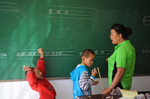 9月7日,語文老師指導(dǎo)兩位聽障學(xué)生寫漢語拼音,由于溝通困難,他們始終不能規(guī)范地書寫漢語拼音“e”。 “來這個地方,必須有愛,還要有一顆為了孩子做什么都可以的心。”內(nèi)蒙古自治區(qū)呼和浩特市特殊教育學(xué)校校長王河說。 教師節(jié)前夕,記者來到內(nèi)蒙古自治區(qū)呼和浩特市特殊教育學(xué)校,感受耕耘在特教一線老師們的喜怒哀樂,探訪這群為殘疾兒童打開心靈之窗的“爸爸媽媽”們。 程顯榮1979年進入這所學(xué)校,從此和特教結(jié)下了30多年的不解之緣。“該嚴厲的時候要嚴厲,該靈活的時候要靈活。”程顯榮說,和特殊孩子們交流,溝通上會有局限,而一些抽象的詞匯也很難通過手語清晰地表達出來,所以一定要耐得住性子。 這些特教老師們普遍說話嗓門大、語速比較急,甚至?xí)治枳愕?。老師們說,嗓門大是為了讓尚有一些聽力的孩子聽到聲音,手勢較多則是為了讓孩子更好地理解老師們的意思,補充聽力殘缺造成的溝通不暢。“也算是一種職業(yè)病吧!”老師們笑著說。 這所始建于1958年的特殊教育學(xué)校目前共有84名教師,其中專業(yè)技術(shù)人員68人。今年新學(xué)期學(xué)生報名人數(shù)有132人,其中聽力障礙學(xué)生108人,視力障礙學(xué)