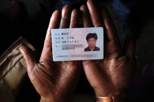 12月7日,遇難礦工胡云江的母親捧著兒子的身份證。 新華社記者 江宏景 攝