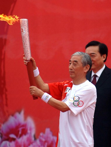奧運(yùn)圣火在洛陽傳遞 7月27日,第一棒火炬手張海在起跑儀式上舉起火炬。當(dāng)日,北京奧運(yùn)圣火在河南省洛陽市傳遞。 新華社記者朱祥攝