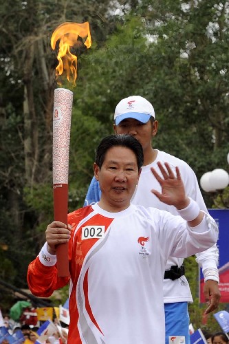 6月21日,火炬手李素芝手持火炬?zhèn)鬟f。當日,北京奧運會圣火傳遞活動在西藏拉薩舉行。 新華社記者普布扎西攝