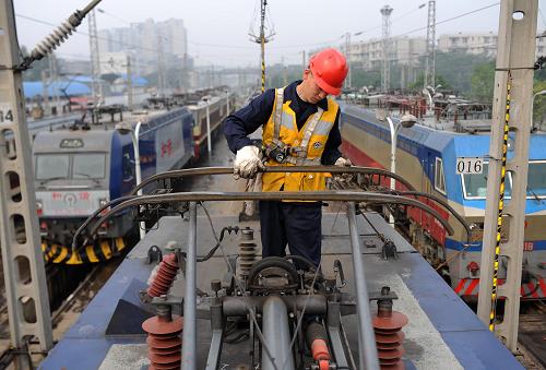 10月3日,在成都鐵路局成都機務(wù)段成都整備車間,工作人員在檢查機車車頂?shù)氖茈姽?。國慶長假期間,成都鐵路局成都機務(wù)段成都整備車間160余名鐵路職工堅守崗位,每趟機車返回入庫后,都要對機車進行檢查、維修、清洗等內(nèi)容的整備作業(yè),確保每臺火車頭都以最佳狀態(tài)為旅客服務(wù)。新華社記者 薛玉斌 攝