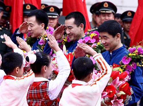 9月29日,神舟七號(hào)3名航天員接受少先隊(duì)員獻(xiàn)花。當(dāng)日,北京航天城舉行儀式,歡迎圓滿完成任務(wù)的神七航天員翟志剛、劉伯明、景海鵬凱旋。 新華社記者 陳建力 攝
