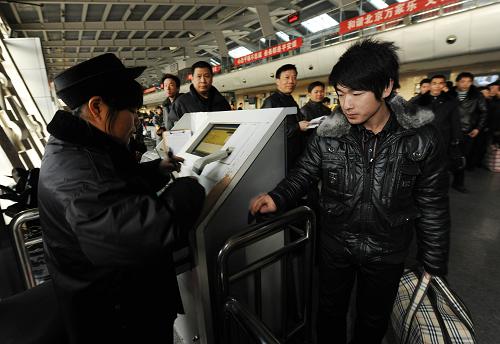 1月30日,在北京六里橋長(zhǎng)途客運(yùn)汽車樞紐站,旅客們?cè)跈z票上車。 新華社記者 金良快 攝
