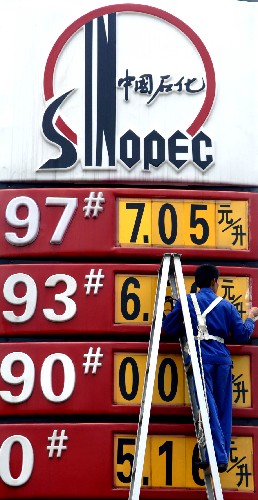 2007年11月1日,海南省東線高速公路一處中國石化加油站的工作人員在更換價格牌。 新華社發(fā)