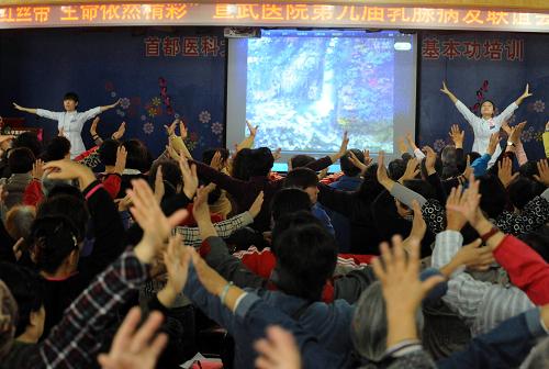 10月19日,北京宣武醫(yī)院普外科醫(yī)護人員在指導(dǎo)患者學(xué)做術(shù)后健身操。