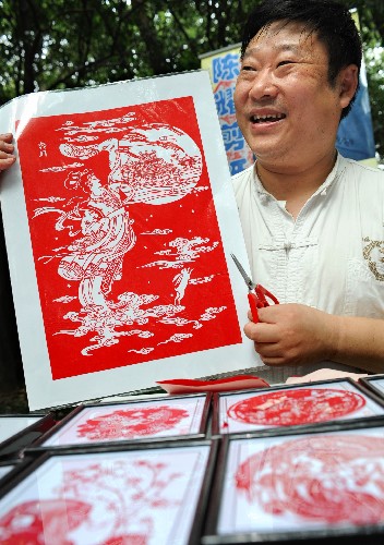 9月13日,南京剪紙藝人陳耀向游人介紹他的剪紙作品“嫦娥奔月”。新華社記者 孫參 攝