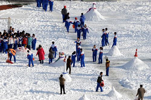 1月5日,北京一所學(xué)校的學(xué)生課間在積雪的操場上堆雪人。新華社記者 李文 攝