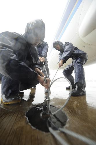 9月29日,在??谑忻捞m機(jī)場(chǎng),工作人員固定未離港飛機(jī)為臺(tái)風(fēng)“納沙”登陸做準(zhǔn)備。