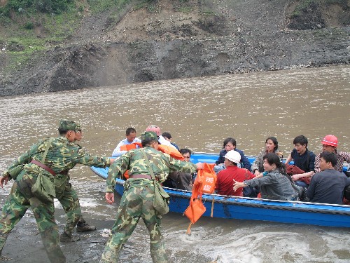 5月14日,抵達(dá)汶川縣映秀鎮(zhèn)的解放軍幫助汶川縣映秀鎮(zhèn)被困人員坐上快艇準(zhǔn)備轉(zhuǎn)移到安全地帶。 新華社記者 侯大偉攝