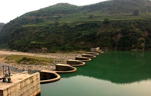 這是河南省嵩縣木植街鄉(xiāng)修建的一座水電站攔河壩(2007年9月11日攝)。農(nóng)村“以電代燃”工程的實(shí)施,使祖居深山的農(nóng)民改變了傳統(tǒng)的以柴取暖、做飯習(xí)慣,用上了清潔、便利的小水電能源。新華社記者 王頌 攝