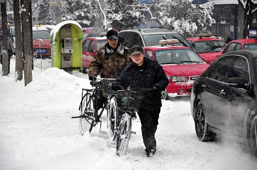 3月15日,在牡丹江市街頭,兩位市民在風(fēng)雪中推著自行車前行。黑龍江省部分地區(qū)從3月14日下午開始降大到暴雪,已對交通產(chǎn)生一定影響。至15日上午,黑龍江省內(nèi)大部分高速公路被迫關(guān)閉,黑龍江省氣象部門兩次發(fā)布暴雪藍(lán)色預(yù)警信號,一些地區(qū)降雪仍將持續(xù)。新華社發(fā)(張春祥 攝)