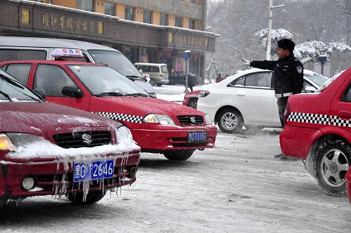 3月15日,牡丹江市一位交警冒著風(fēng)雪在街頭疏導(dǎo)車輛。新華社發(fā)(張春祥 攝)