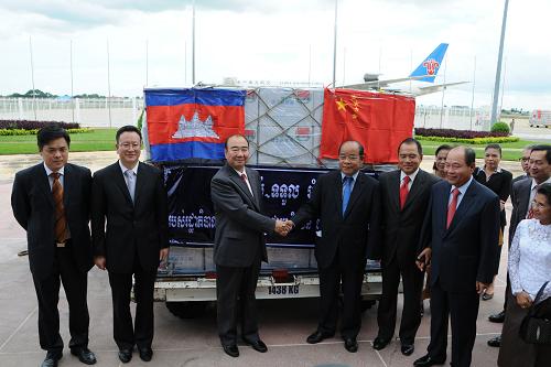 10月15日,在柬埔寨首都金邊國際機場,中國駐柬大使潘廣學(xué)(前左三)和柬國家救災(zāi)委員會副主席寧萬達(dá)(前左四 )在救災(zāi)物資交接儀式上握手。新華社記者 雷柏松 攝