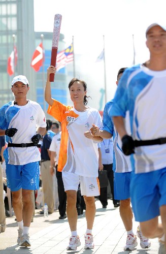 9月2日,第一棒火炬手吳春苗手持火炬?zhèn)鬟f。當(dāng)日,北京殘奧會(huì)圣火在青島進(jìn)行傳遞。新華社記者 徐亮 攝