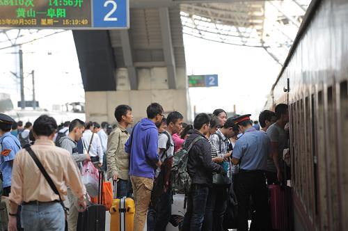9月30日,合肥火車站內(nèi)出行的旅客排隊(duì)上車。當(dāng)日是國(guó)慶假期前一天,全國(guó)各地迎來國(guó)慶長(zhǎng)假首個(gè)出行高峰。新華社發(fā)(楊曉原 攝)