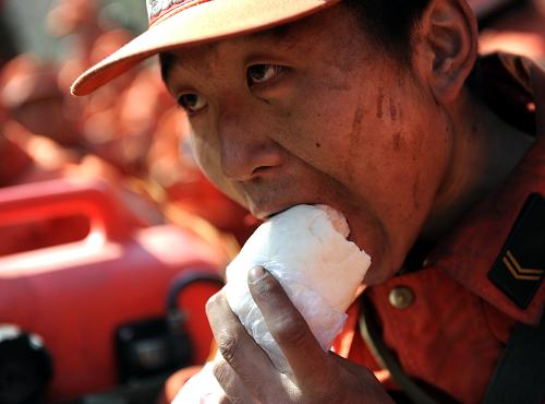 秦皇島“4·12”森林大火仍在緊張撲救 4月15日,疲憊的戰(zhàn)士在東峪林場起火點附近就地用餐。 當(dāng)日,記者從秦皇島“4·12”森林大火撲救工作指揮部獲悉,經(jīng)過廣大官兵和當(dāng)?shù)馗刹咳罕姷木o張撲救,到14日21時,四號區(qū)域明火已全部撲滅,一、二、三號區(qū)域火勢得到有效控制。但由于14日夜間的6-7級大風(fēng),且風(fēng)向由南向北轉(zhuǎn)移,方家河、東峪林場以南和以東地區(qū)再次出現(xiàn)火點,目前正在積極組織撲救,同時將根據(jù)天氣進(jìn)行人工增雨作業(yè)。 4月12日中午,河北省秦皇島市撫寧縣和青龍縣交界處突發(fā)森林火災(zāi)。 新華社記者 楊世堯攝
