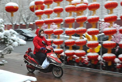 2月10日,一位騎電動(dòng)車的市民在上班途中。2月9日,鄭州天空中飄起雪花,久旱的河南大地迎來了第一場春雪。 由于降雪量不大,加上氣溫偏高,至10日凌晨,路上積雪基本已經(jīng)融化,市內(nèi)絕大部分道路暢通,市民出行沒有受到太大影響。新華社記者 王頌 攝